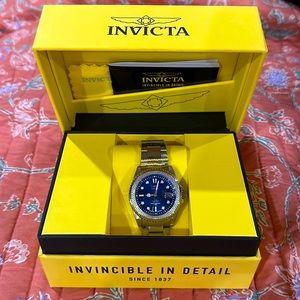 Invicta brand silver women’s watch. Blue face with diamond decor around clock.